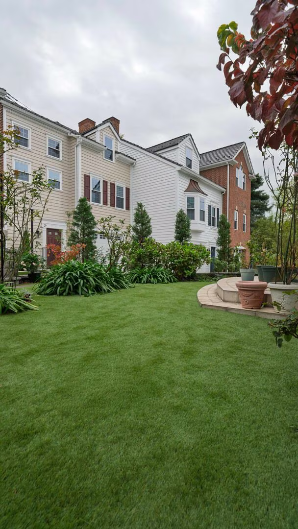 住宅の庭一面に敷いた GREEN VIGOR。円形テラスと植栽に囲まれた芝生