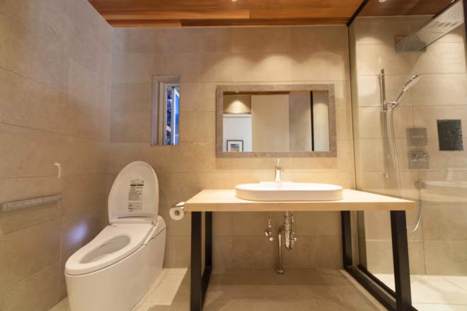 トイレと洗面を並べた、ベージュタイルの落ち着いた水まわり