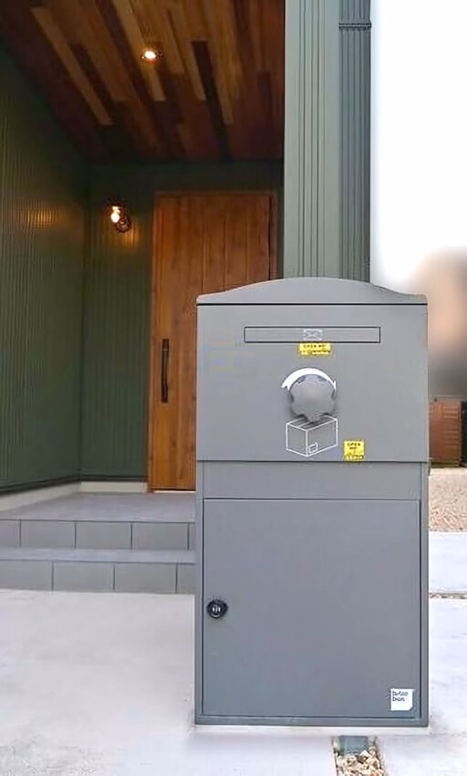 木製ドアの前に設置した、グレーの大容量宅配ボックスBrizebox Ex-Large